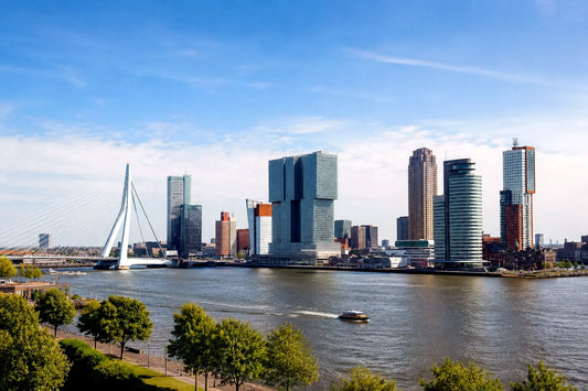 breedbeeldfoto van de moderne skyline van Rotterdam met de iconische Erasmusbrug bij zonsondergang – stijlvolle landmarkfoto voor meubels herstofferen en meubelstoffering in Rotterdam.