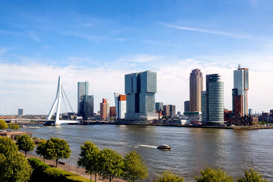 breedbeeldfoto van de moderne skyline van Rotterdam met de iconische Erasmusbrug bij zonsondergang – stijlvolle landmarkfoto voor meubels herstofferen en meubelstoffering in Rotterdam.
